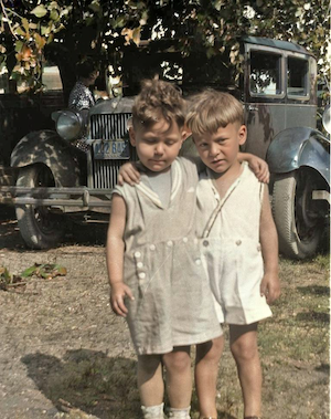 Harry Lieberman left, Stanley Dumes right. Both Stan and Harry were born in 1926. Stan is wearing the same clothes as he wore in the 1929 reunion photo, but the license plate on the car says 